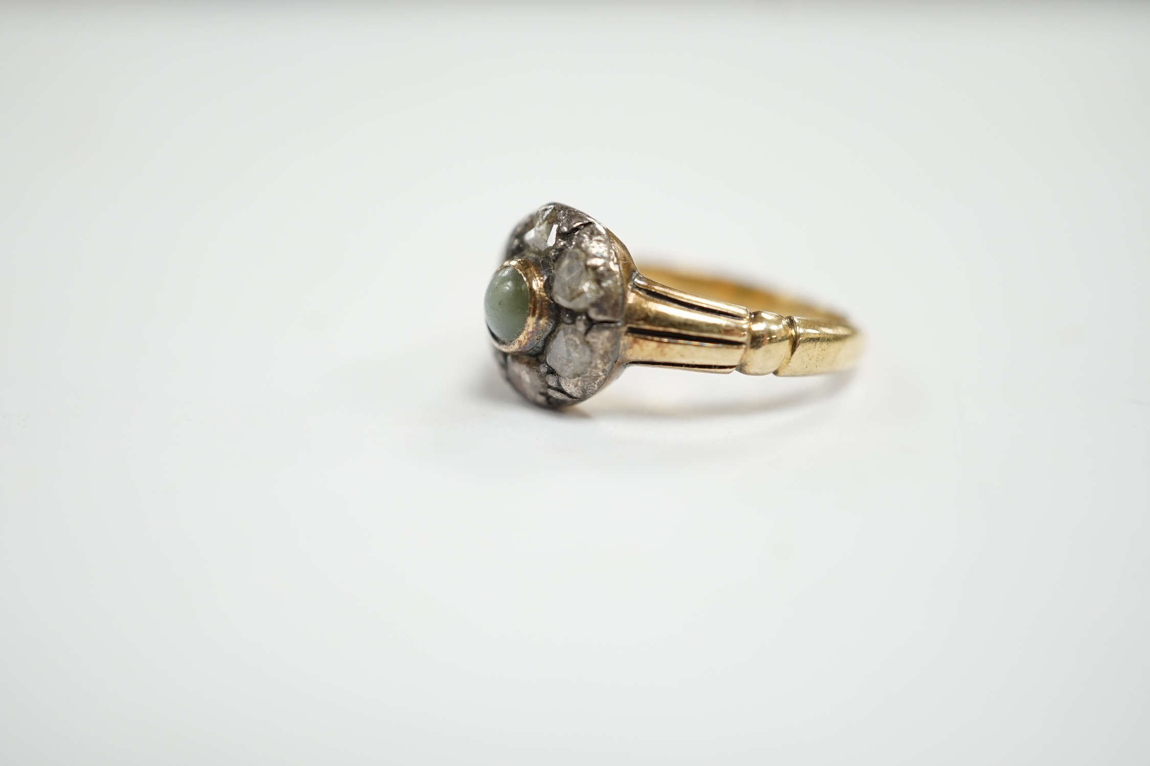 An early 20th century 18ct, cat's eye chrysoberyl and rose cut diamond set circular cluster ring, size M, gross weight 4.6 grams.